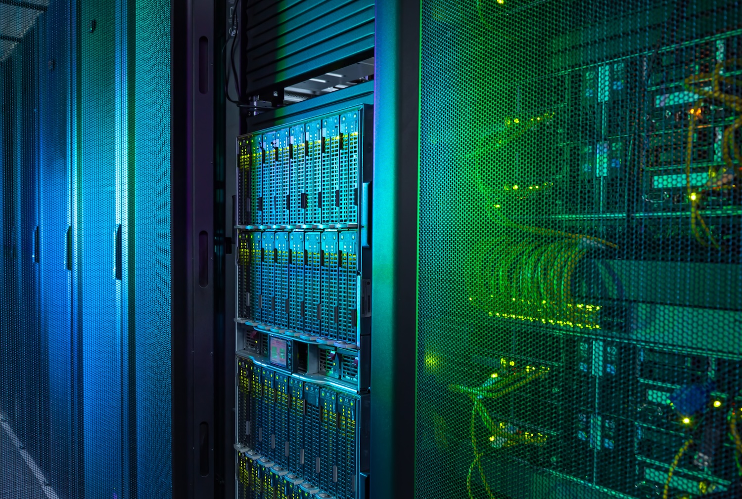 Datacenter server racks dramatically lit with green and blue light